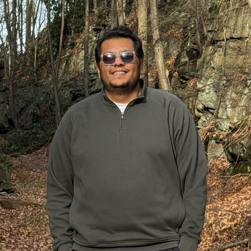 Dhruv Patel smiling on a wooded trail